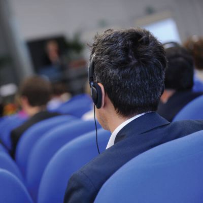 Attendee wearing headphones at a conference, using Skrivanek’s interpreting services for multilingual communication.