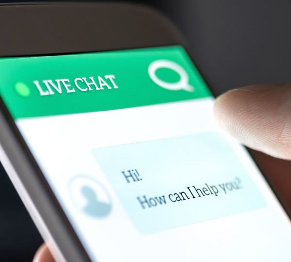 Smartphone mit einer Live-Chat-Schnittstelle, die digitale Interaktion und KI-gesteuerte Kommunikation durch die Chatbots von Skrivanek symbolisiert.