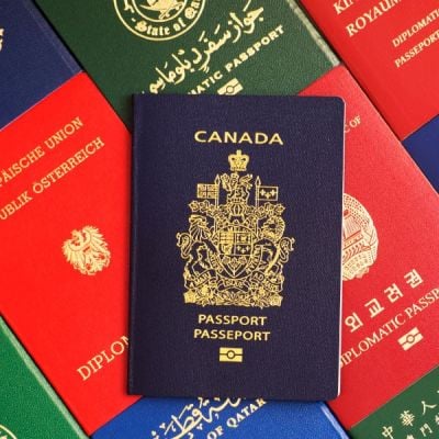 A Canadian passport superimposed on passports from various countries, illustrating Skrivanek's document translation and notarisation services.