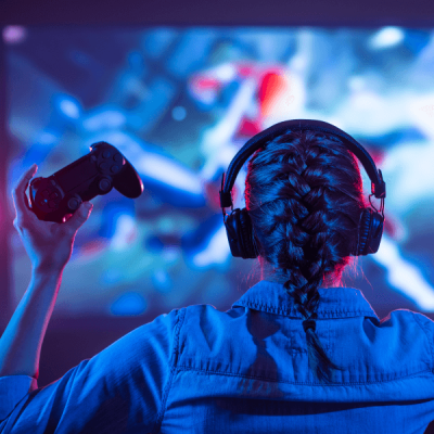 A gamer playing on a large screen referring to Skrivanek Baltic's translation and localisation services for the IT and gaming industries.