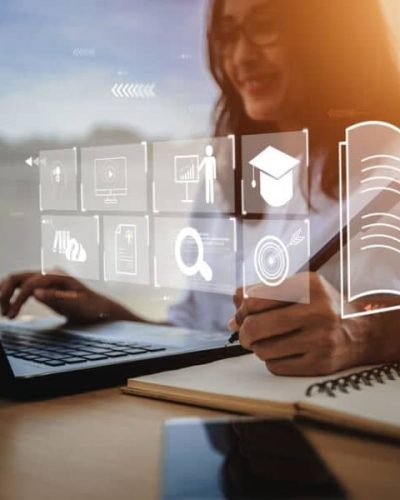 Cilvēks strādā pie klēpjdatora ar atvērtu digitālu saskarni, veicot pierakstus kladē; vizuāls simbols piekļūstamības principu nozīmei skaidras, paredzamas un lietotājam draudzīgas informācijas nodrošināšanā