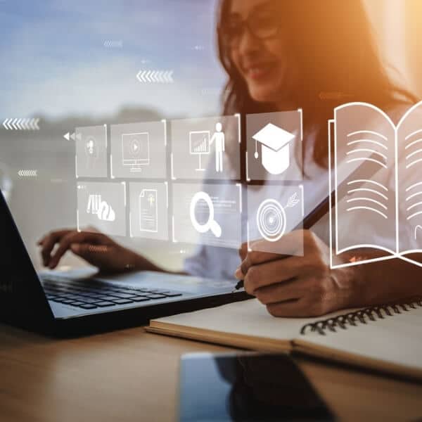 Cilvēks strādā pie klēpjdatora ar atvērtu digitālu saskarni, veicot pierakstus kladē; vizuāls simbols piekļūstamības principu nozīmei skaidras, paredzamas un lietotājam draudzīgas informācijas nodrošināšanā